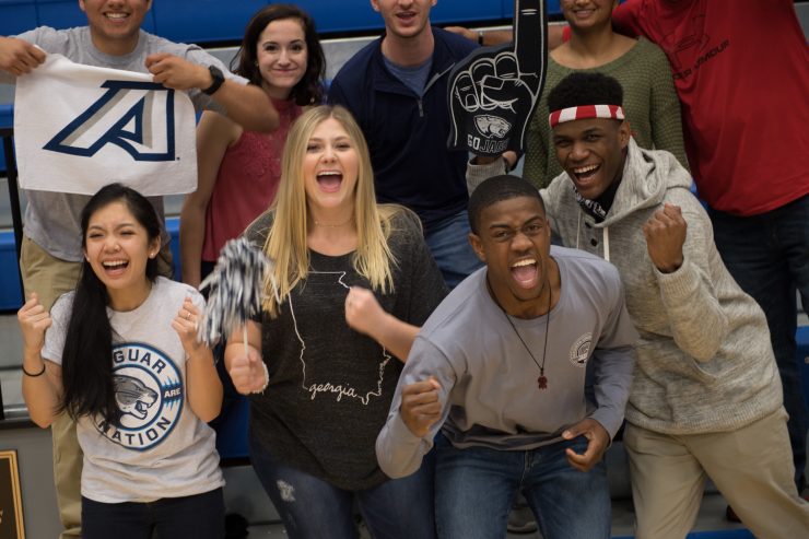 Augusta University students cheer at a basketball game.
