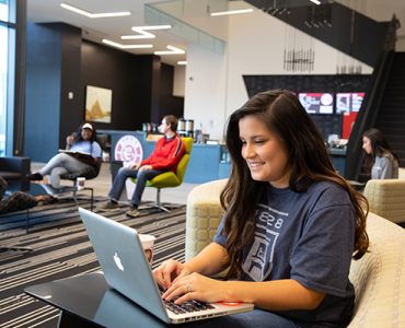 Female student smiling while working on resume
