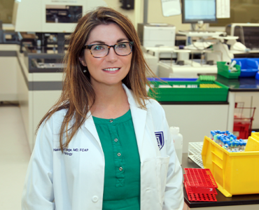 Female physician smiling in science lab